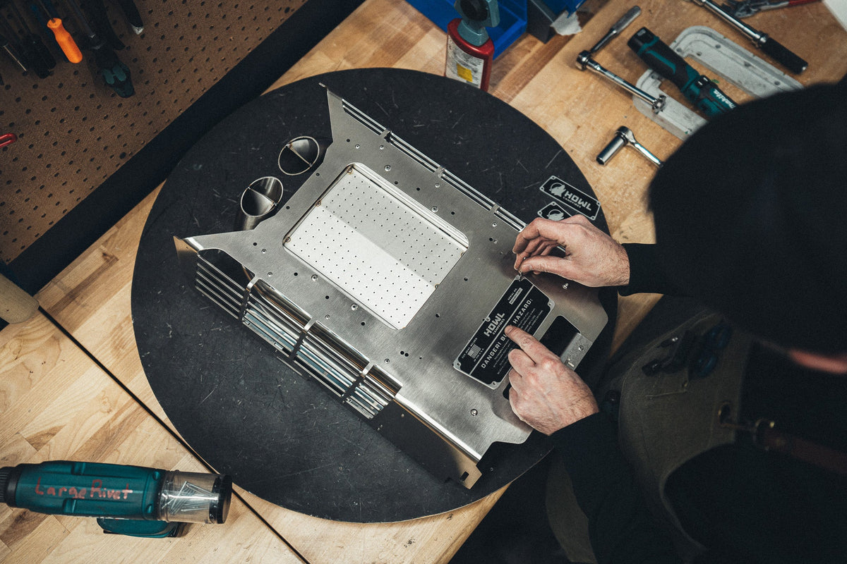 Assembly technician building a HOWL propane fire pit