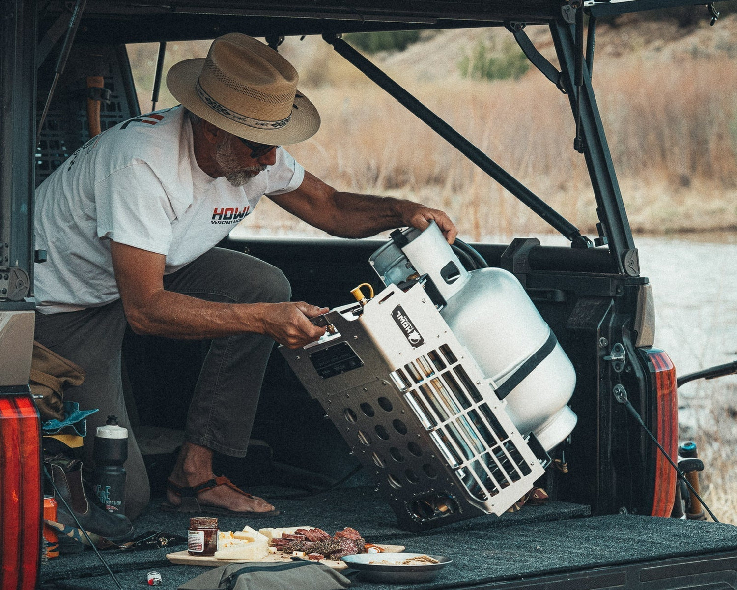 HOWL campfire strapped to a propane tank for secure transport in a vehicle cargo area