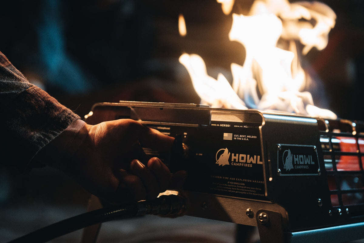 A camper turning the Mission Control Knob on a HOWL R3 Propane Fire Pit